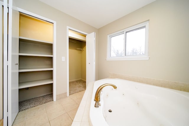 bathroom featuring tile patterned flooring and tiled tub