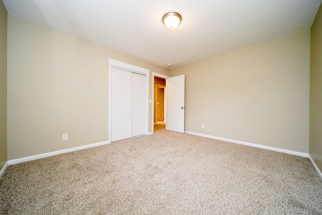 unfurnished bedroom featuring carpet floors and a closet