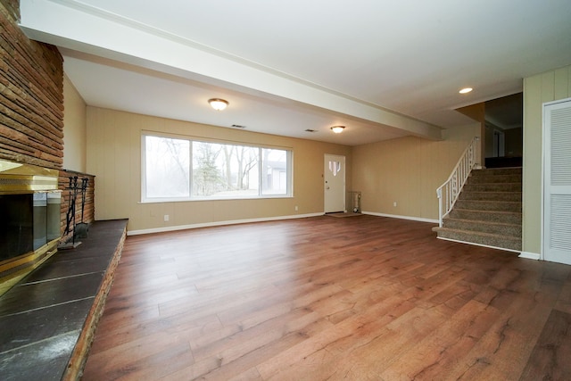 unfurnished living room featuring a fireplace and hardwood / wood-style flooring