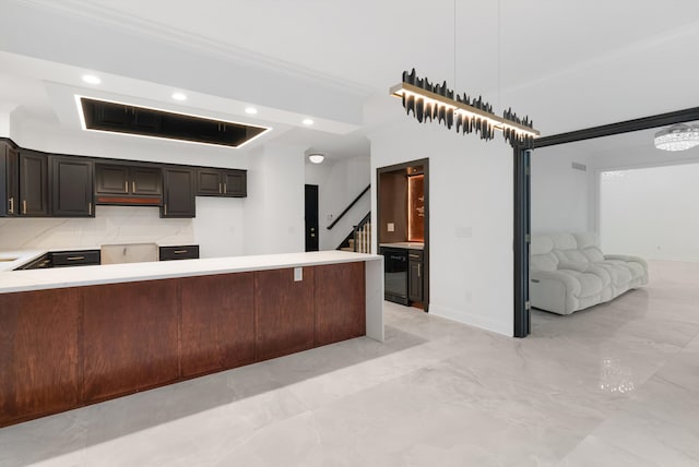 kitchen featuring a breakfast bar area, hanging light fixtures, kitchen peninsula, ornamental molding, and tasteful backsplash