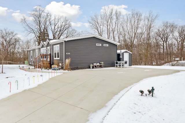 view of snowy exterior featuring a shed