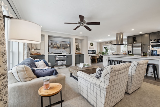 carpeted living room with ceiling fan