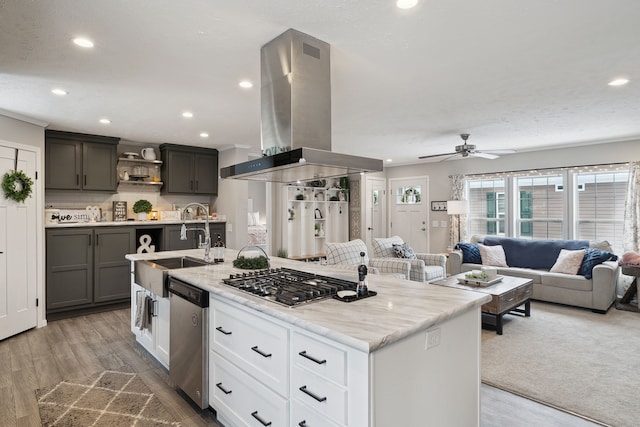 kitchen with white cabinetry, stainless steel appliances, island exhaust hood, hardwood / wood-style floors, and an island with sink