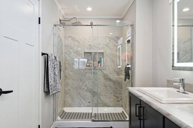 bathroom with vanity, a shower with door, and crown molding