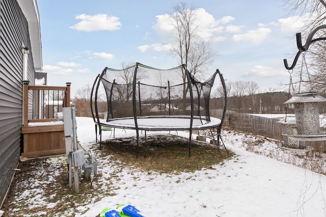 yard layered in snow with a trampoline