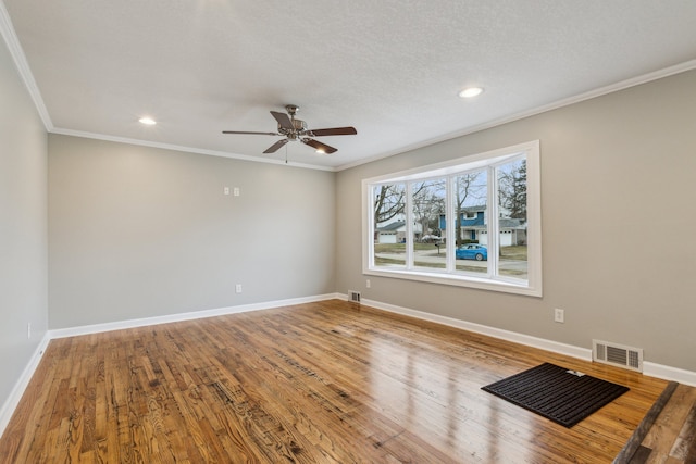 unfurnished room featuring wood-type flooring, a textured ceiling, ceiling fan, and crown molding