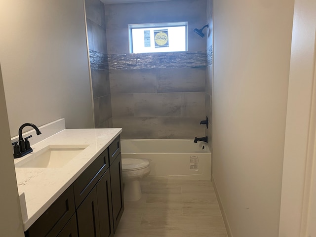 full bathroom with toilet, vanity, and tiled shower / bath