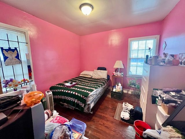 bedroom with dark wood-type flooring