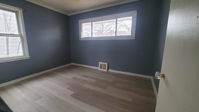 spare room with wood-type flooring and a healthy amount of sunlight