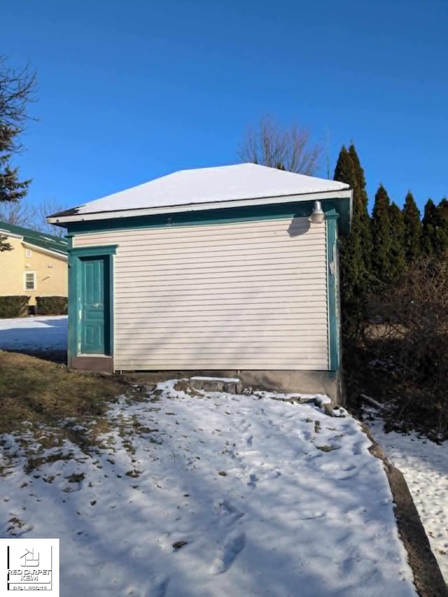 view of snowy exterior featuring an outbuilding