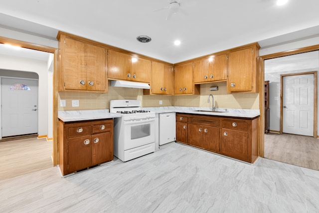 kitchen featuring white appliances, backsplash, ceiling fan, and sink