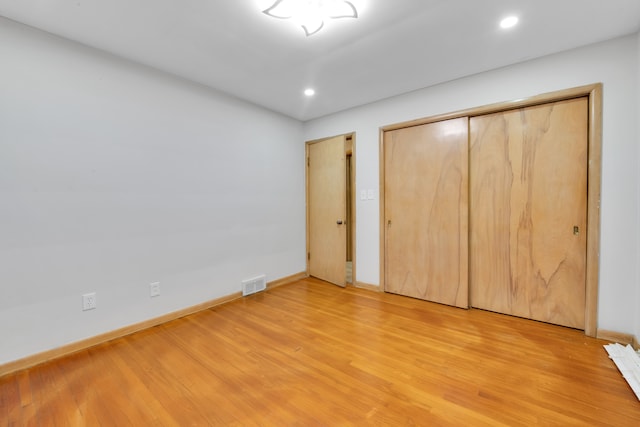 unfurnished bedroom with light hardwood / wood-style floors and a closet