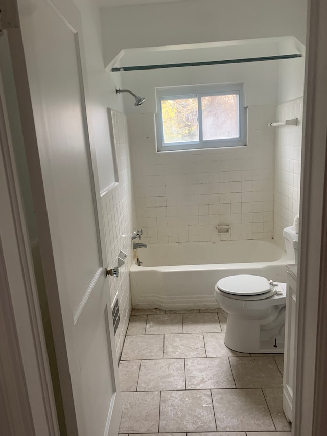 full bathroom featuring tile patterned floors, vanity, toilet, and tiled shower / bath combo