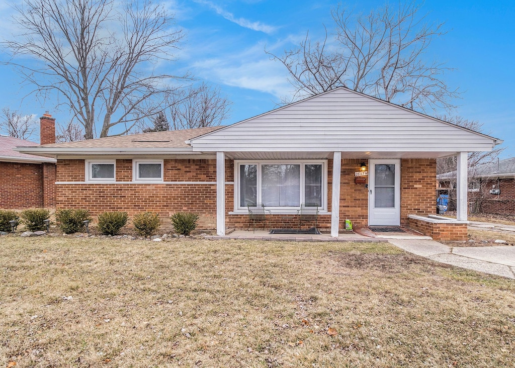 single story home featuring a porch and a front yard