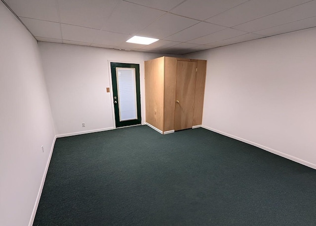 carpeted spare room featuring a drop ceiling