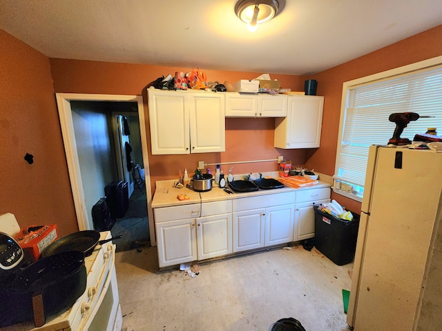 kitchen featuring white cabinets and white refrigerator