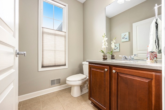 half bathroom featuring vanity, tile patterned flooring, visible vents, toilet, and baseboards