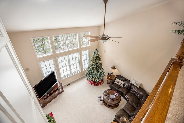 carpeted living room with a towering ceiling and ceiling fan