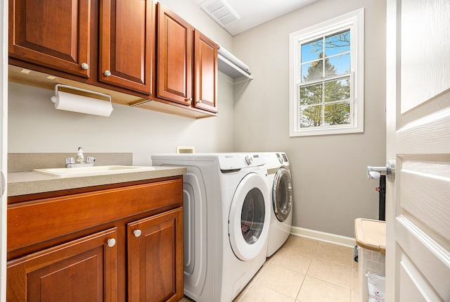 clothes washing area featuring cabinet space, light tile patterned flooring, separate washer and dryer, and a sink