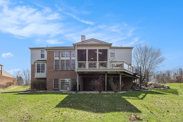 rear view of property featuring brick siding, a sunroom, and a lawn
