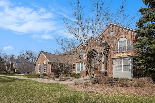 traditional home with brick siding and a front lawn