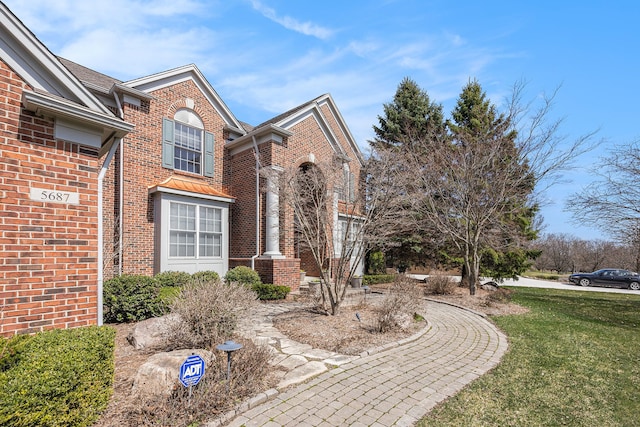 view of front of house with a front yard and brick siding