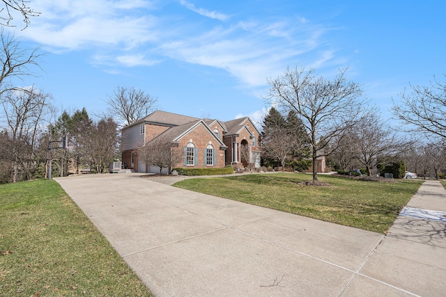 traditional home with concrete driveway, a front yard, and brick siding