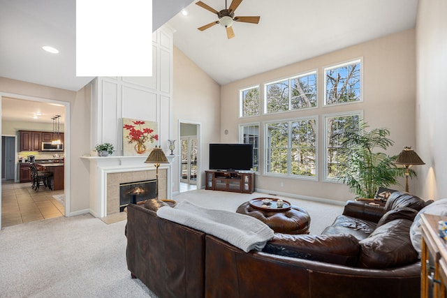 living room with a ceiling fan, recessed lighting, high vaulted ceiling, light colored carpet, and a tile fireplace