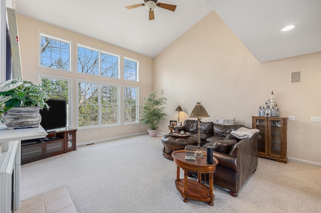 carpeted living area featuring high vaulted ceiling, baseboards, a ceiling fan, and a healthy amount of sunlight