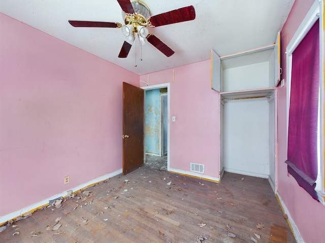 unfurnished bedroom with a closet, dark hardwood / wood-style floors, and ceiling fan