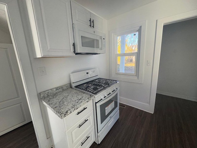 kitchen featuring light stone countertops, dark hardwood / wood-style flooring, white cabinets, and white appliances