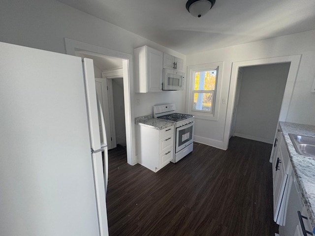 kitchen featuring dark hardwood / wood-style floors, white cabinetry, light stone counters, and white appliances