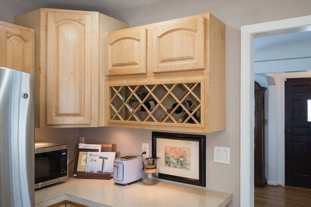 interior space with light brown cabinets and stainless steel appliances