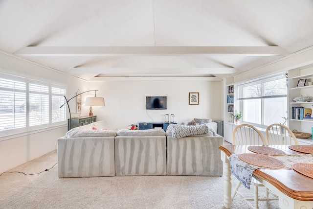 living room with lofted ceiling with beams, light colored carpet, and plenty of natural light