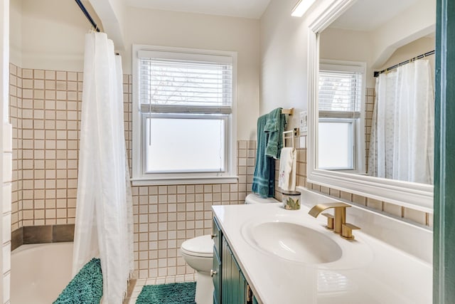 full bathroom featuring vanity, a healthy amount of sunlight, tile walls, tile patterned flooring, and toilet