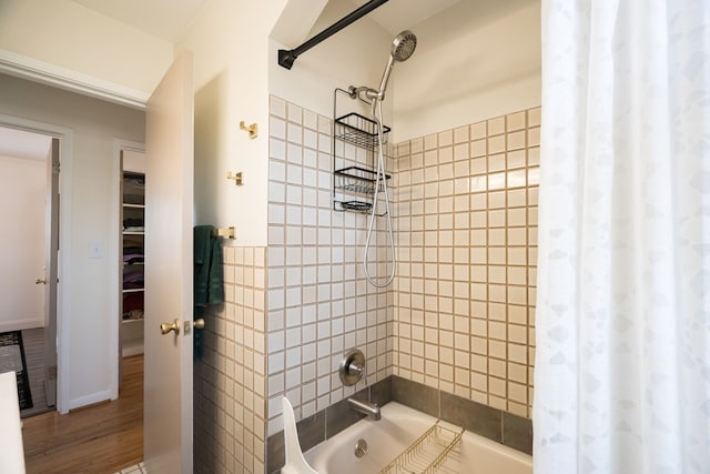 bathroom featuring wood-type flooring and shower / bath combo with shower curtain