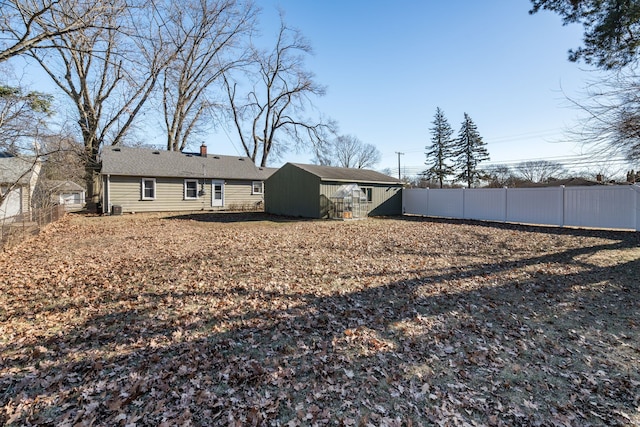 back of house with a storage unit