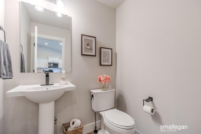 bathroom featuring lofted ceiling and toilet