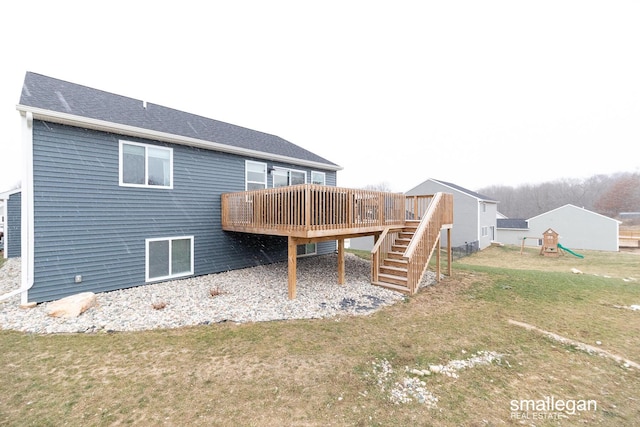 rear view of house with a wooden deck and a yard