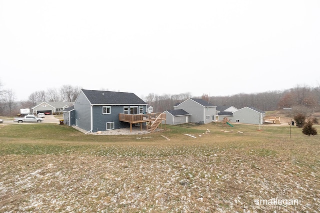 back of property with a yard and a wooden deck