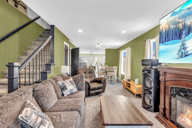 living room featuring a high end fireplace and carpet flooring