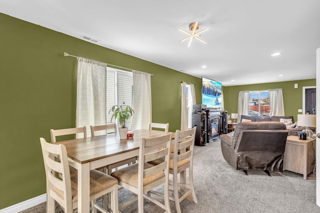 dining area featuring an inviting chandelier and light colored carpet