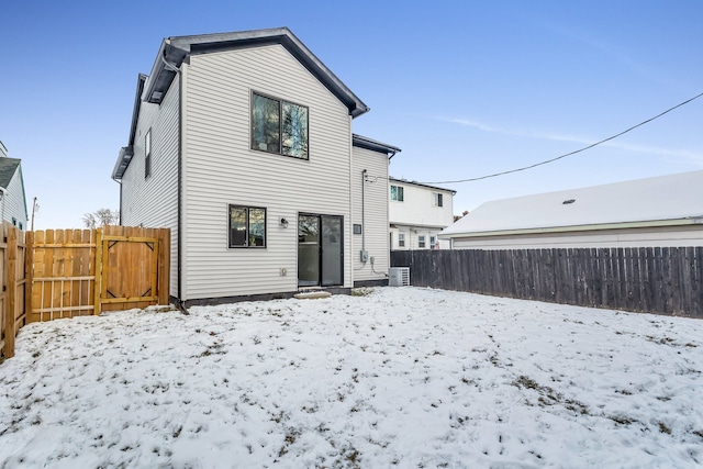 snow covered rear of property with central AC unit