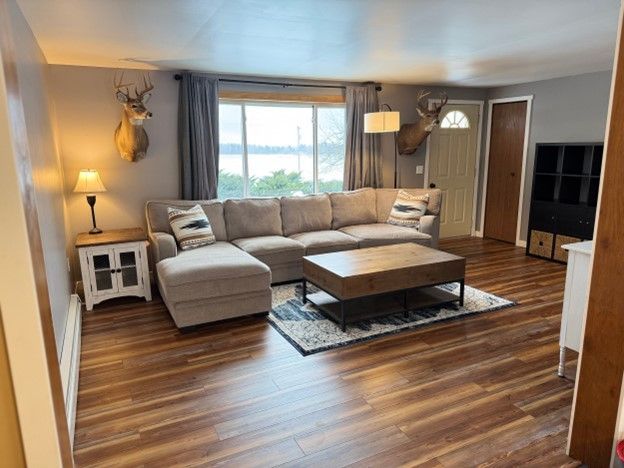 living area featuring a baseboard heating unit and wood finished floors