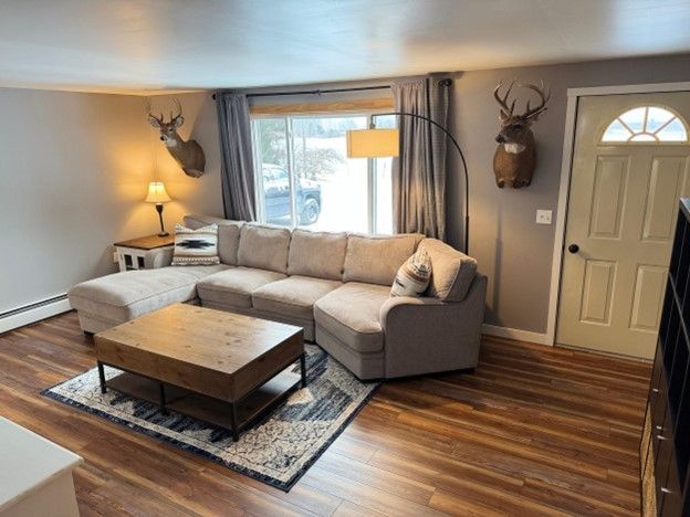 living area with baseboards and wood finished floors