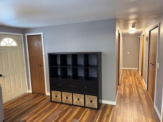 foyer featuring baseboards and wood finished floors