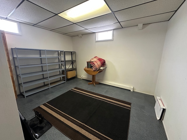 interior space featuring a paneled ceiling, baseboards, and a baseboard heating unit