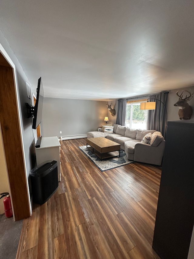 living area with a baseboard radiator, baseboards, and wood finished floors