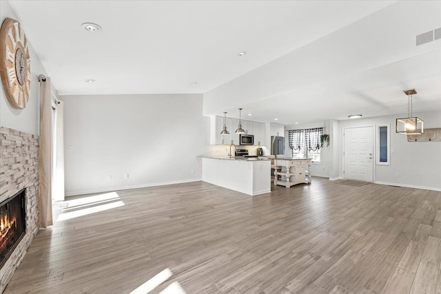 unfurnished living room with a fireplace and light hardwood / wood-style flooring