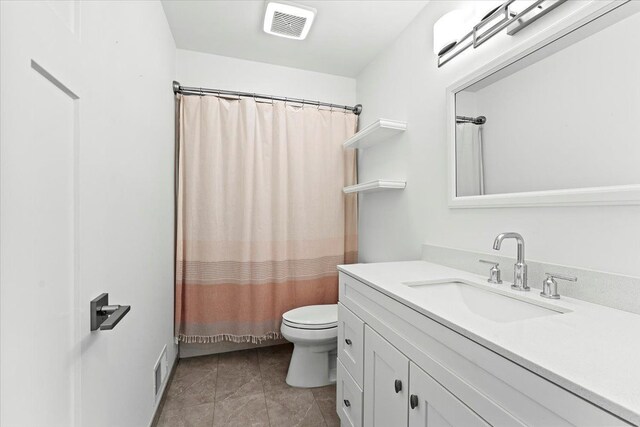 bathroom featuring tile patterned flooring, vanity, and toilet